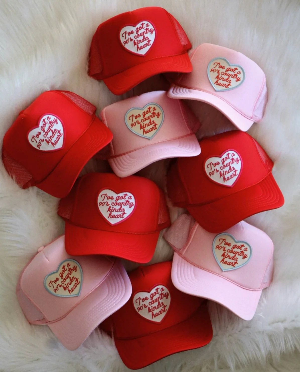 Red and pink trucker hats with heart patches